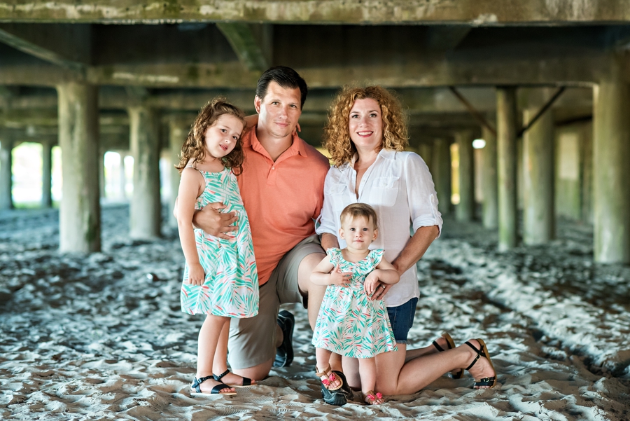 A family pose for a portrait under the boardwalk in Wildwood, NJ.